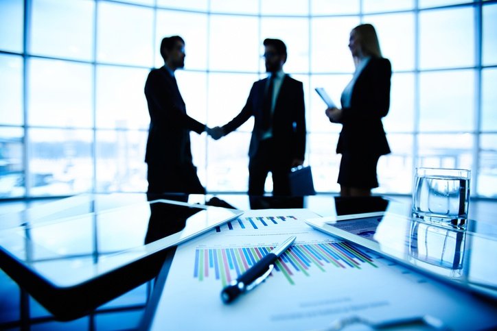 People shaking hands in a boardroom